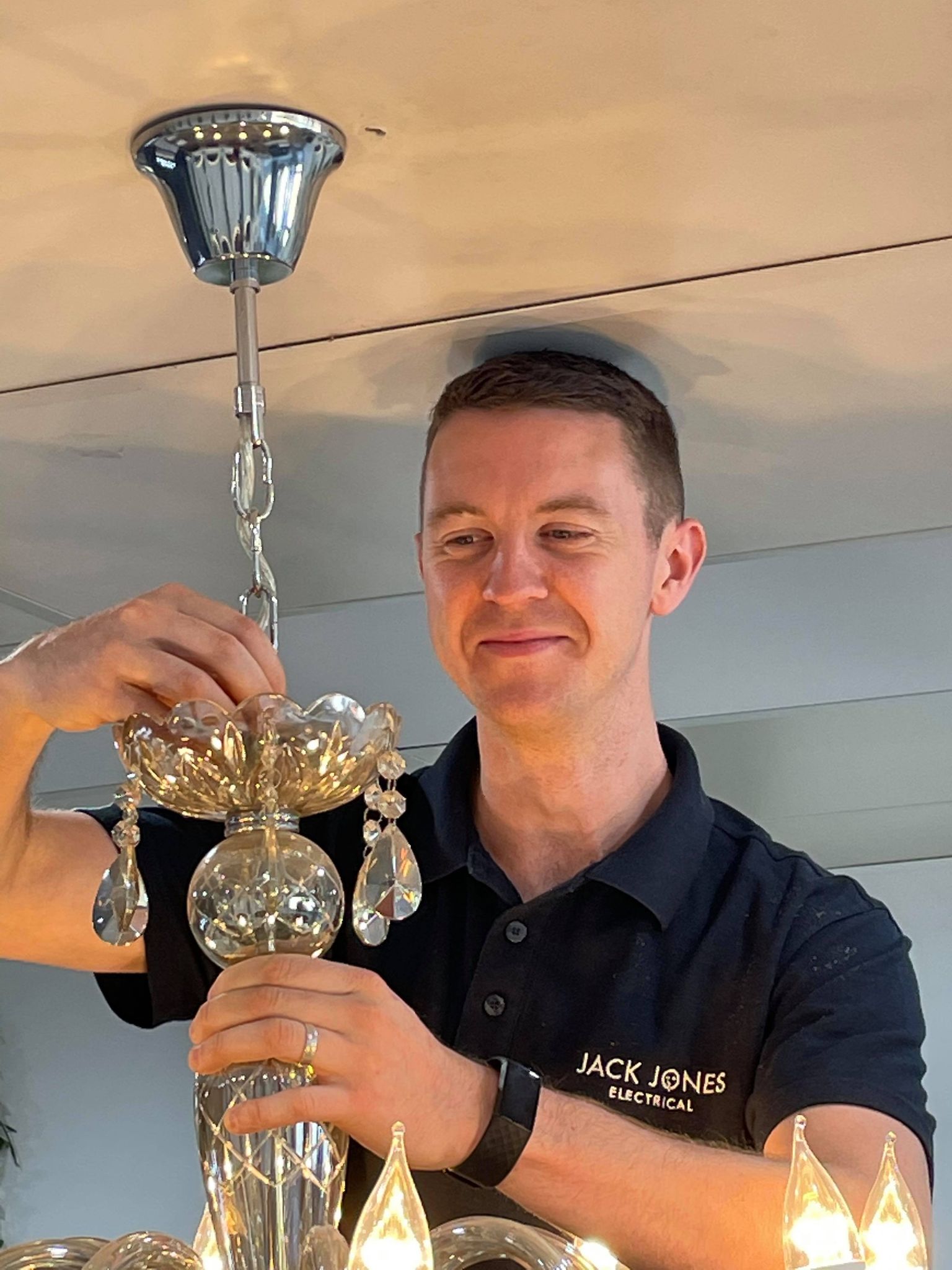 Jack from Jack Jones Electrical installing a chandelier
